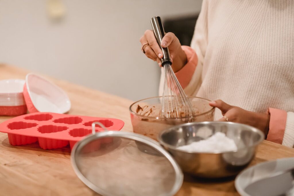 une femme qui cuisine avec des moules en silicones